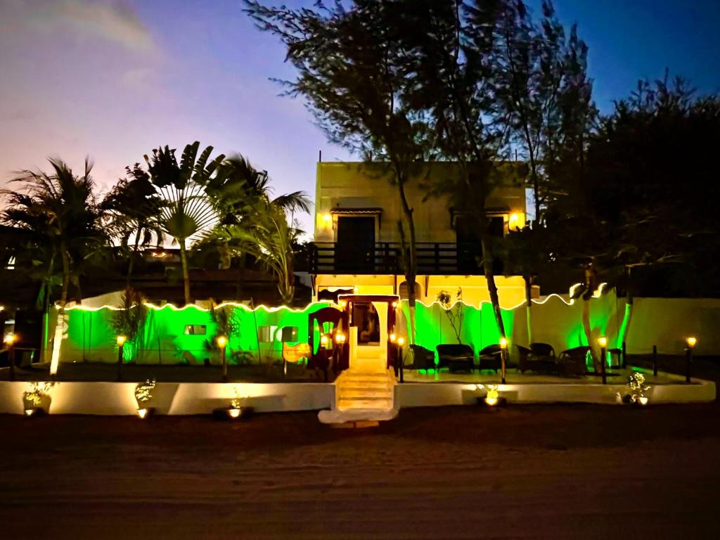 a row of green chairs with lights at night at Villa Veríssimo in Jericoacoara