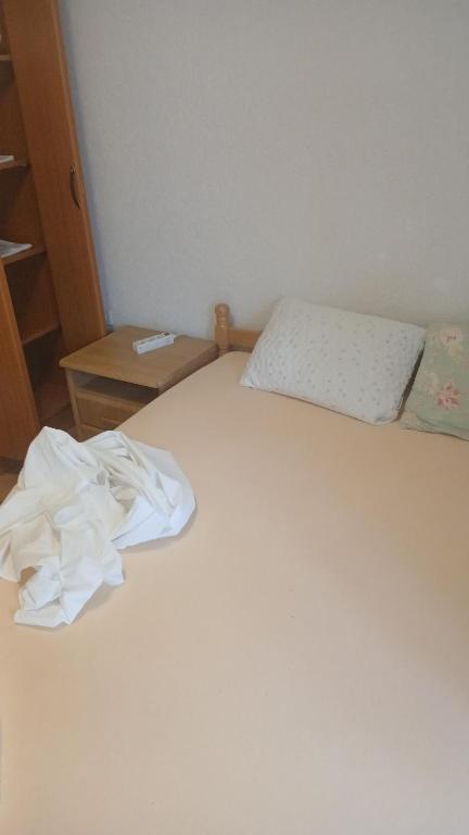 a white bed with a pile of paper on it at Stan in Bar