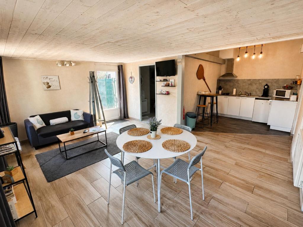 a living room with a table and chairs and a kitchen at CozyCocoon Appartement in Parcey