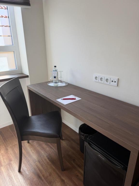 a desk in a room with a chair and a table at Hotel zur Post - Schrobenhausen in Schrobenhausen
