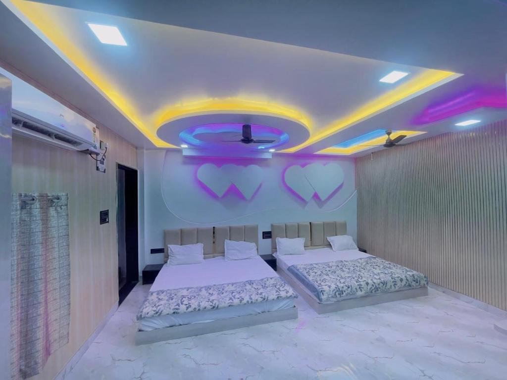 a bedroom with two beds and a purple ceiling at Radhika Cozy Studio Apartment Kitchen 2 Double Beds in Vrindāvan