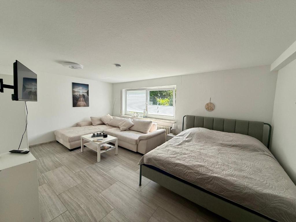 a bedroom with a bed and a couch at Weserglück Ferienwohnung Grohnde in Emmerthal