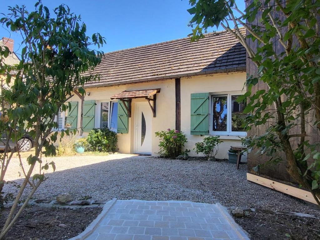 a house with a gravel driveway in front of it at L'Hirondelle in Fourges