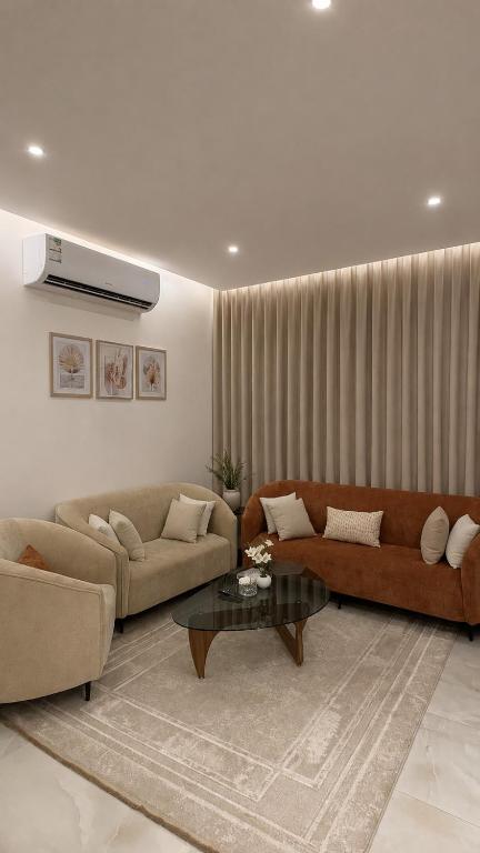 a living room with two couches and a coffee table at شقة بغرفتين نوم وصالة in Hail