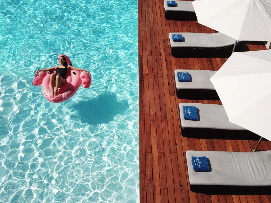 a person is in a pool on a boat at Novotel Athens in Athens