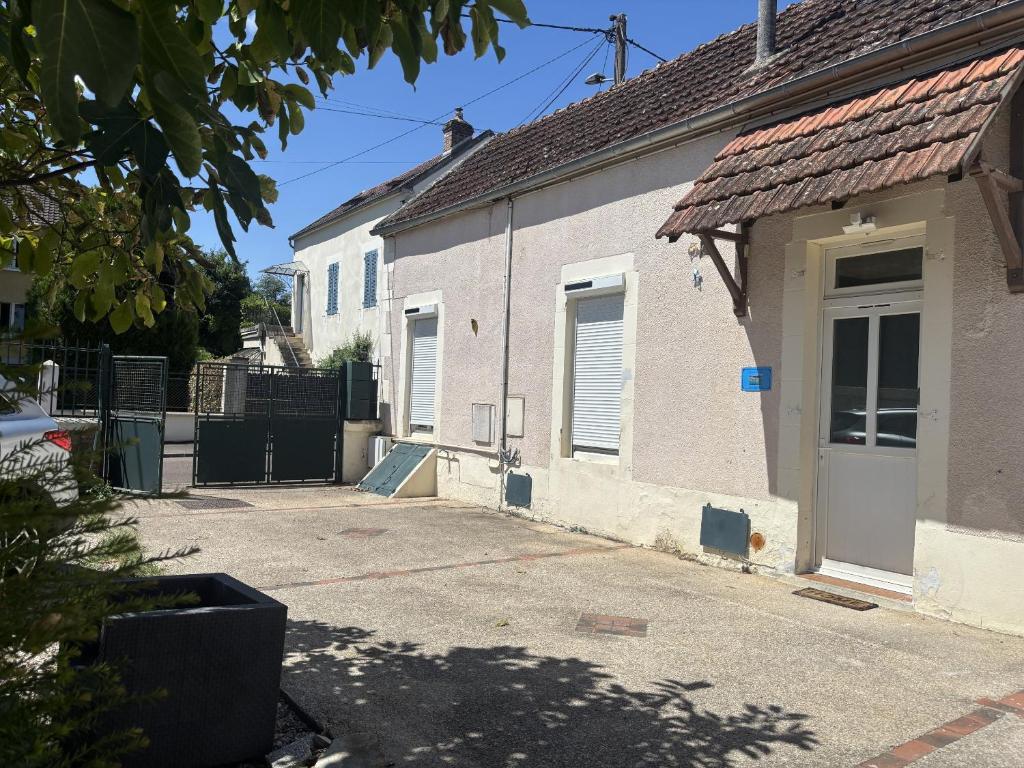 a white house with a gate and a driveway at L’escale féerique in Auxerre