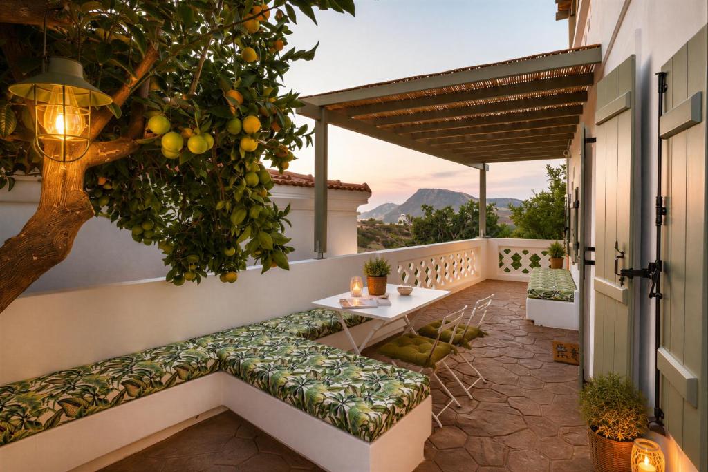 a patio with a bench and a tree on a house at Valandou Guesthouses - Boutique Apartments in Aperi, Karpathos in Karpathos