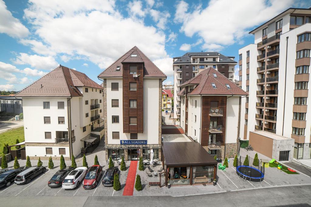 a group of buildings with cars parked in a parking lot at All Seasons Residence in Zlatibor