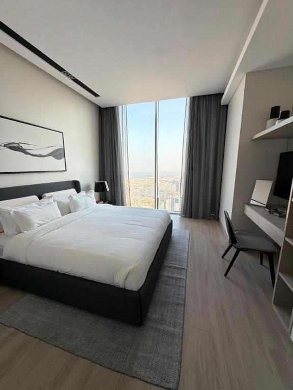 a bedroom with a large bed and a large window at Fontana infinity in Manama