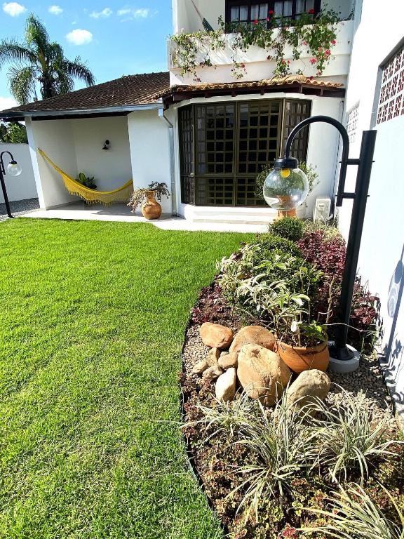 a garden in front of a house with plants at RCM Vilas - Casa Confortável 02 in Joinville