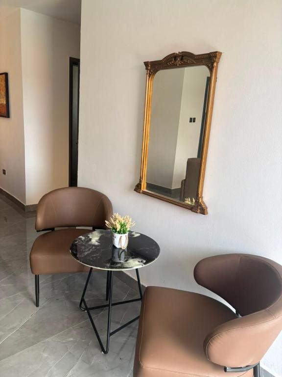 a table and chairs in a room with a mirror at Signature Suite in Bijilo