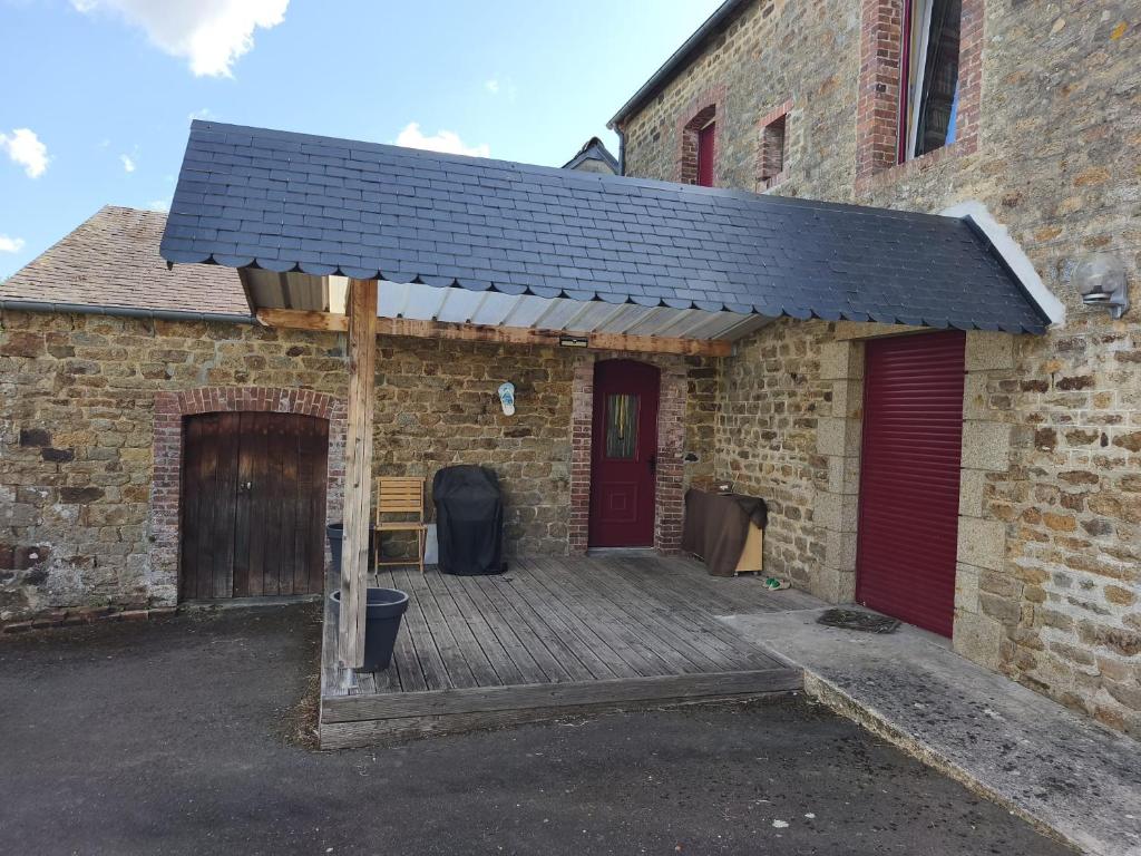 a brick building with a solar roof on a porch at Maison Relax in Flers