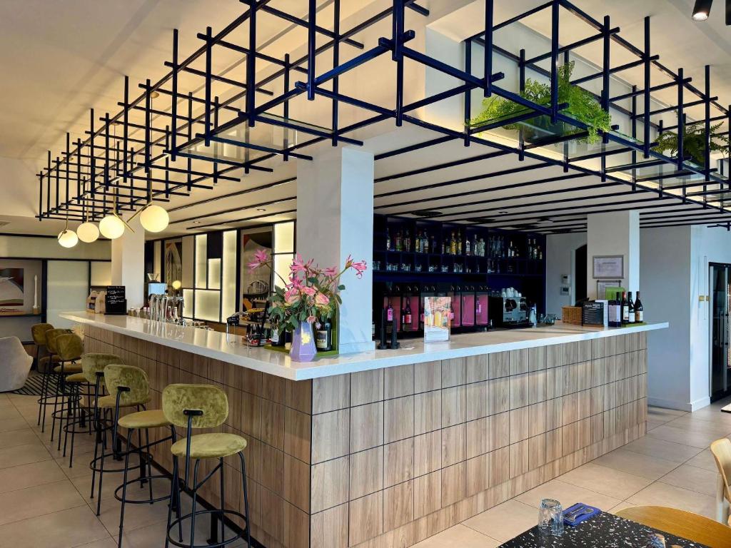 a bar in a restaurant with chairs and tables at Mercure Rouen Val de Reuil in Val de Reuil