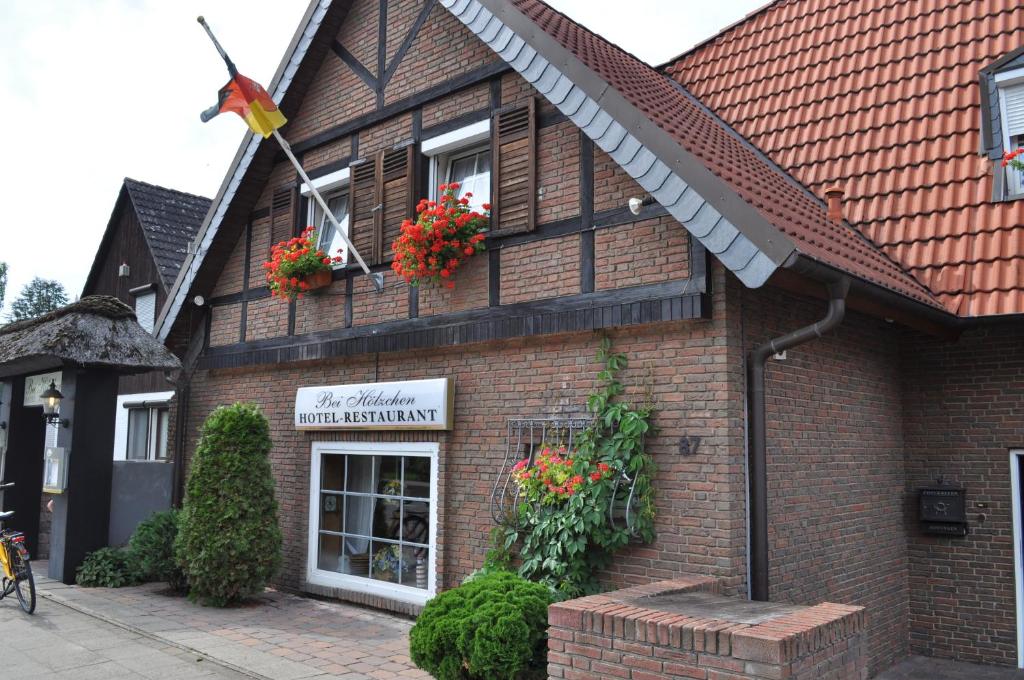 a brick building with flowers in the window at Hotel & Restaurant Bei Hölzchen in Hannover