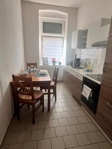 a kitchen with a table and two chairs and a table and a stove at Ferienwohnung Spremberg-City III in Spremberg