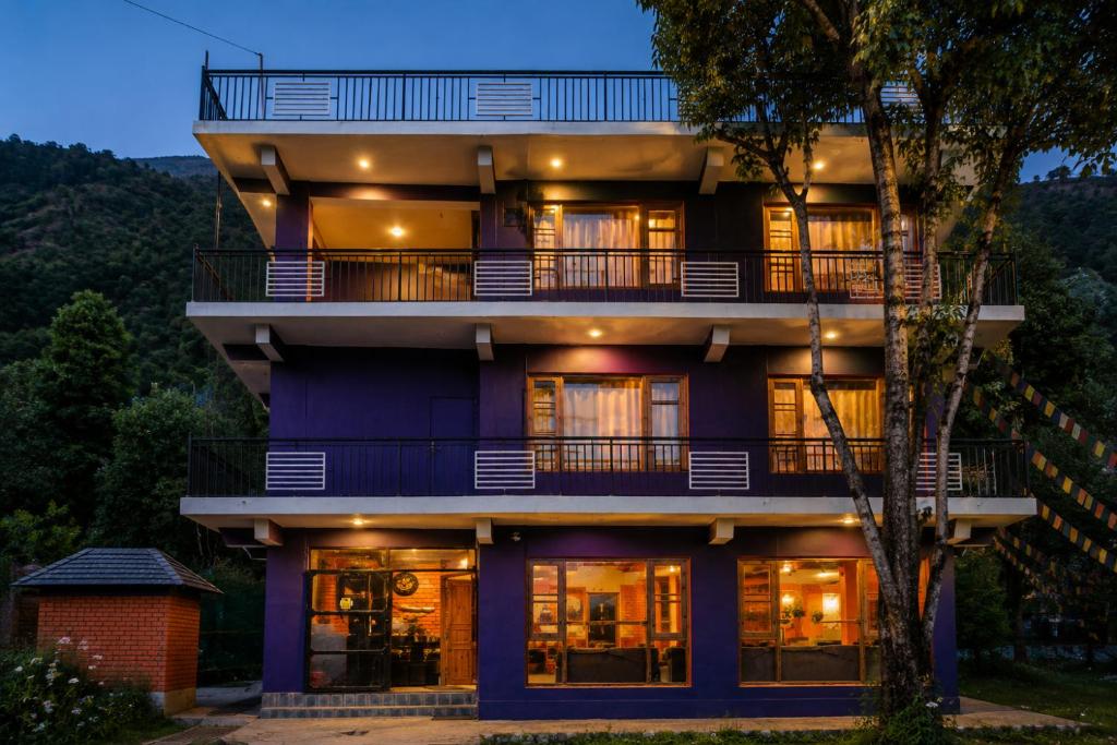 a building with a purple facade at night at Loopin Mcleodganj in McLeod Ganj