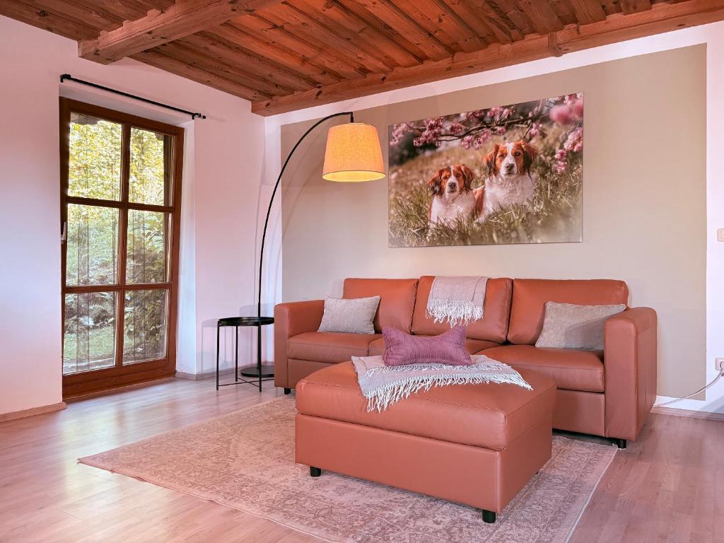 a living room with a brown couch and a table at Ferienwohnung WAUzenberg mit Pool und Sauna in Hauzenberg