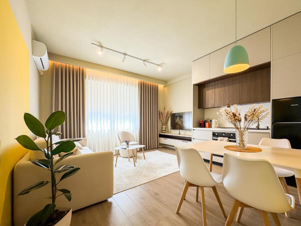 a kitchen and living room with a table and chairs at All Seasons Apartments - Free Parking & City Center in Shkodër