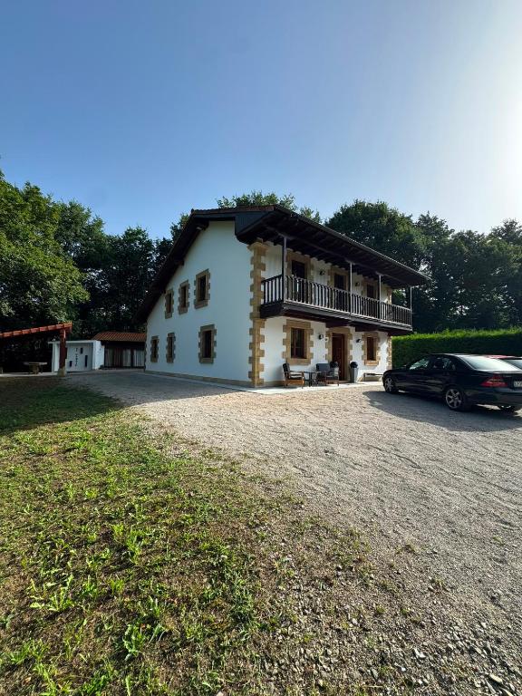 a house with a car parked in front of it at Finca La Sierra in Abionzo