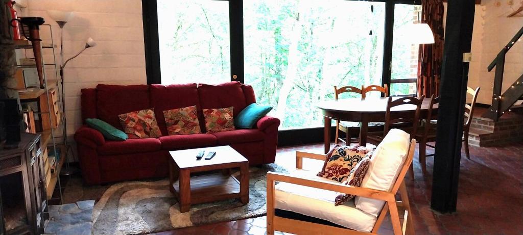 a living room with a red couch and a table at Dix doré in Blaimont