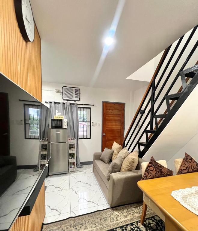 a living room with a couch and a kitchen at J&D Fully-Aircon 400mbps Parking WiFi 6pax in Canaman