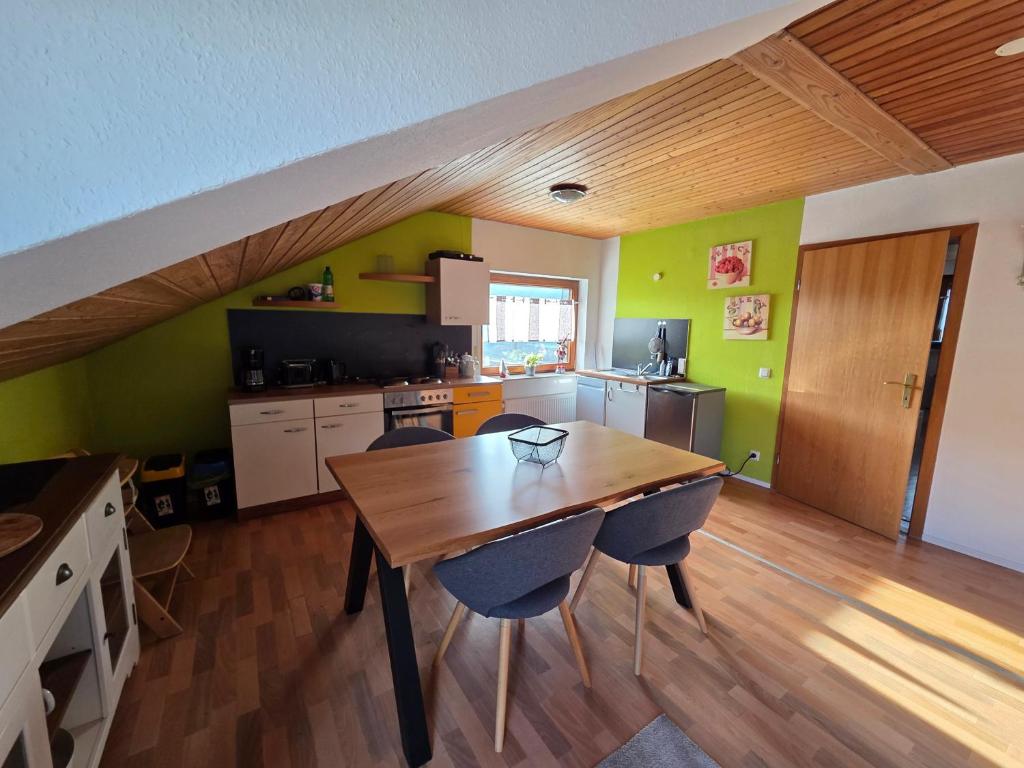 a kitchen and dining room with a wooden table and chairs at Ferienwohnung Riesling in Burg