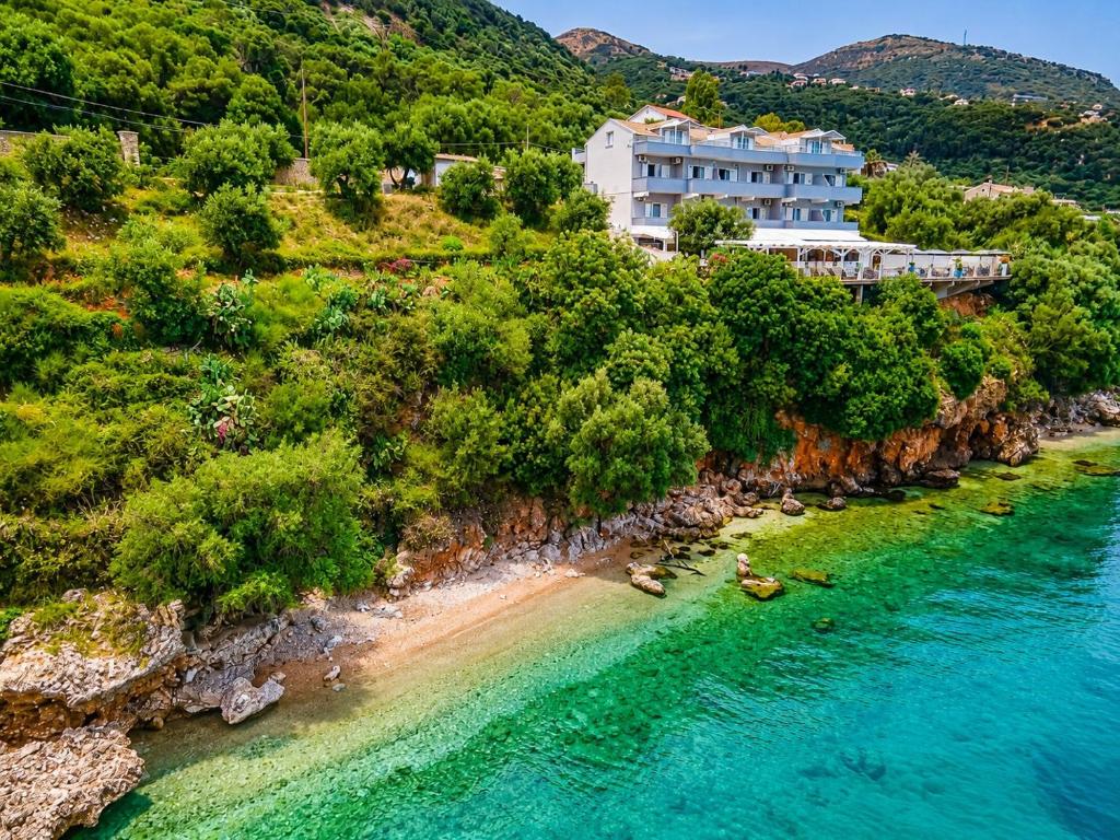 an aerial view of a hotel on a hill next to a beach at Oceanis Rooms Apartments in Barbati