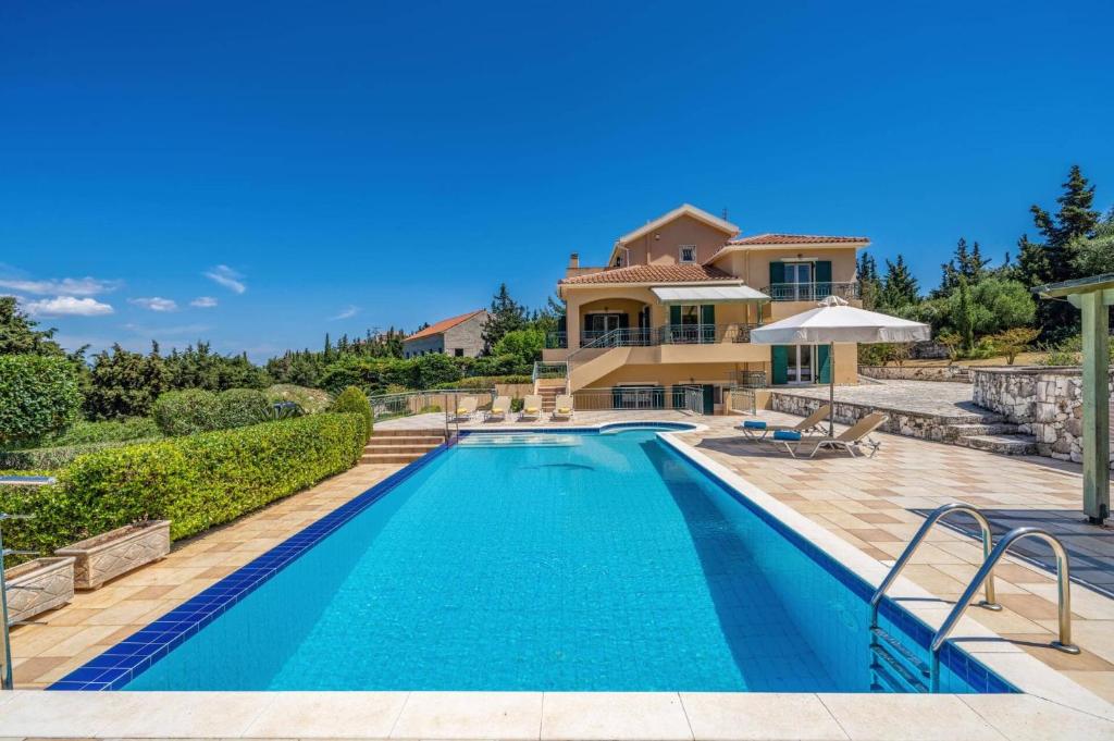 a villa with a swimming pool and a house at Villa Emelisse by Villa Plus in Fiskardo