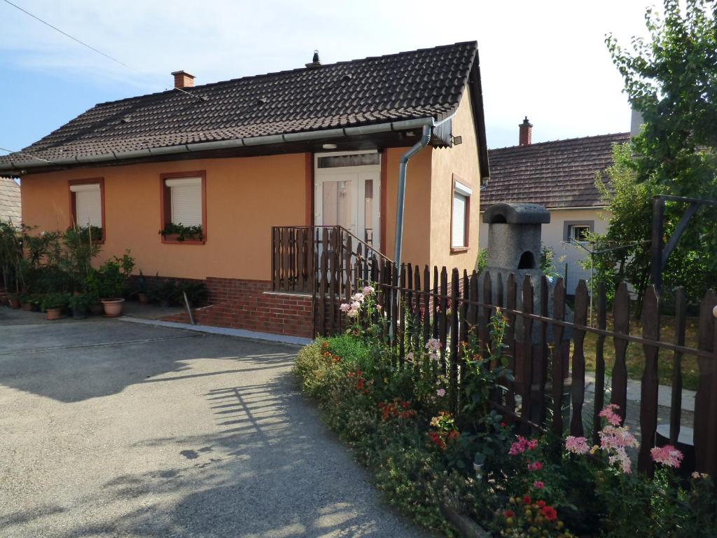 a house with a fence and flowers in front of it at Kovács Vendégház in Zalaegerszeg