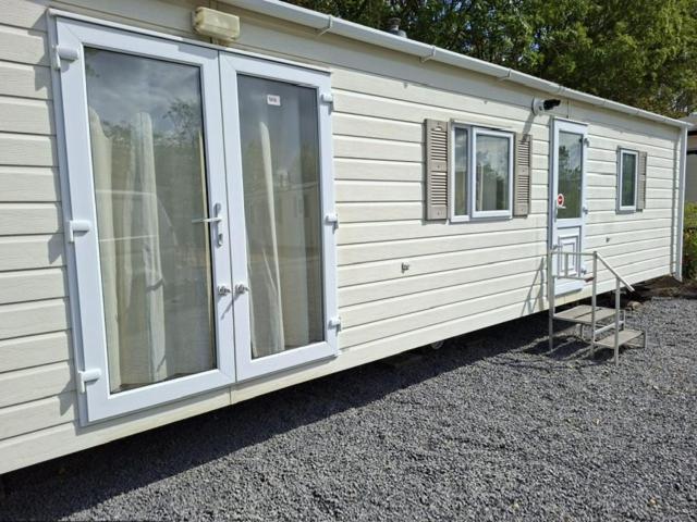 a white trailer with two windows and a ladder at De Zandparel in Poortvliet