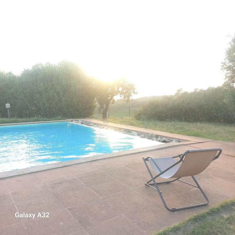 a chair sitting next to a swimming pool at Podere Ortacavoli in Terriccio
