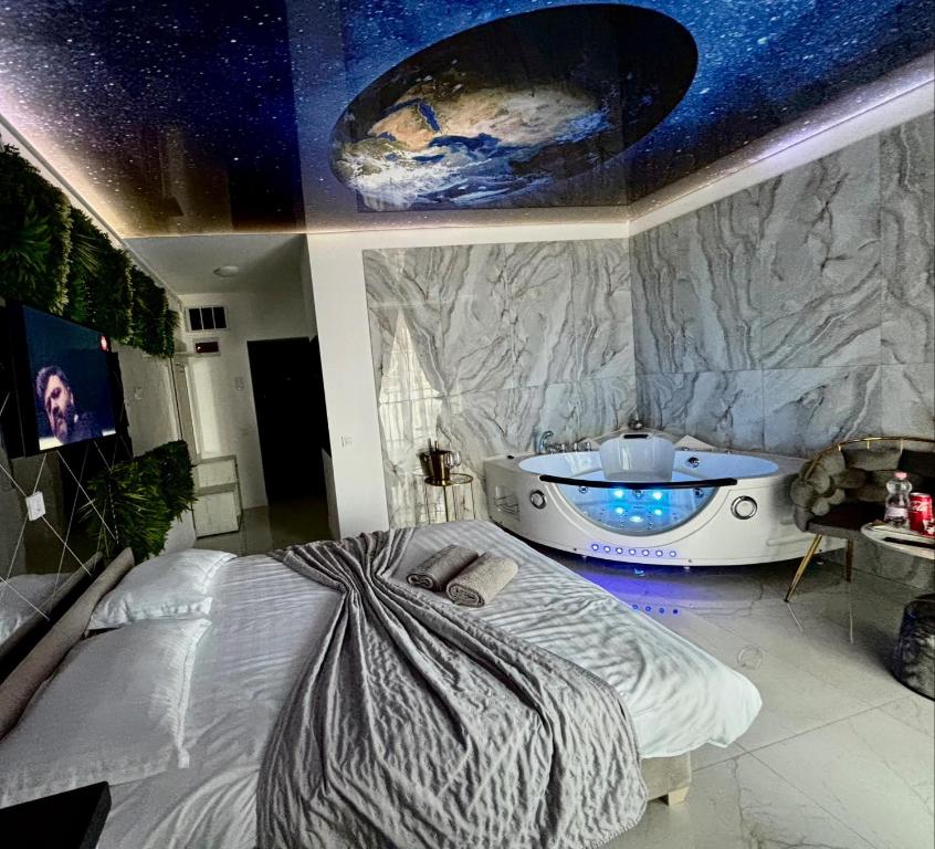 a bedroom with a bed and a bath tub at R U B I room by 50 shades in Baia Mare