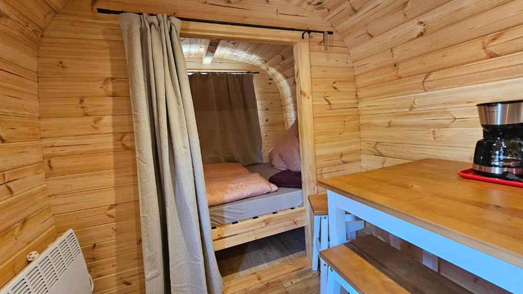 a small room with a bed in a wooden cabin at Camping Schlaffass Naima in Burg