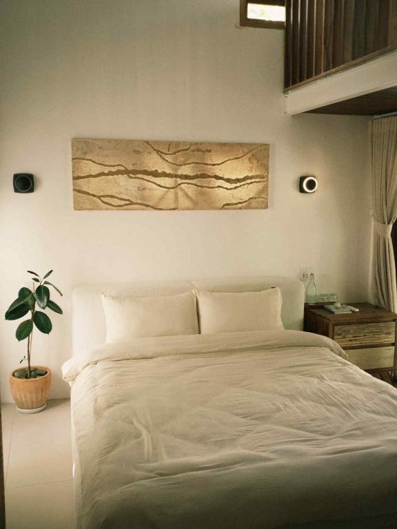 a bedroom with a bed and a painting on the wall at Yên homestay in Phan Rang–Tháp Chàm