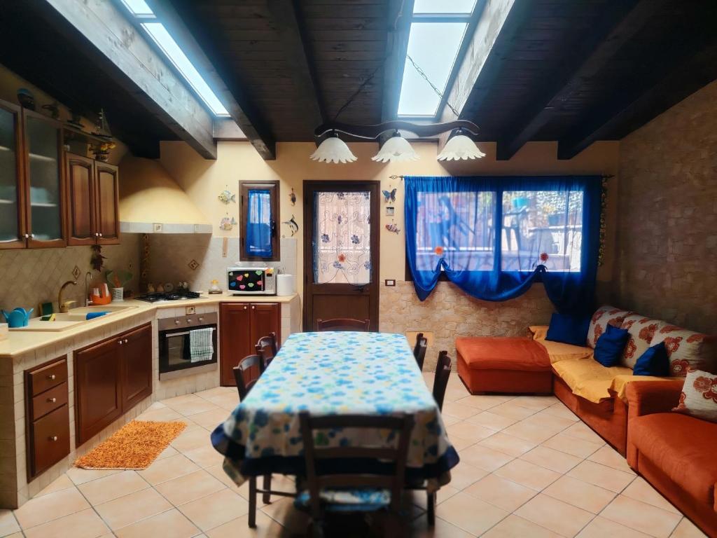 a kitchen and living room with a table and a couch at La perla del mare in Santa Flavia