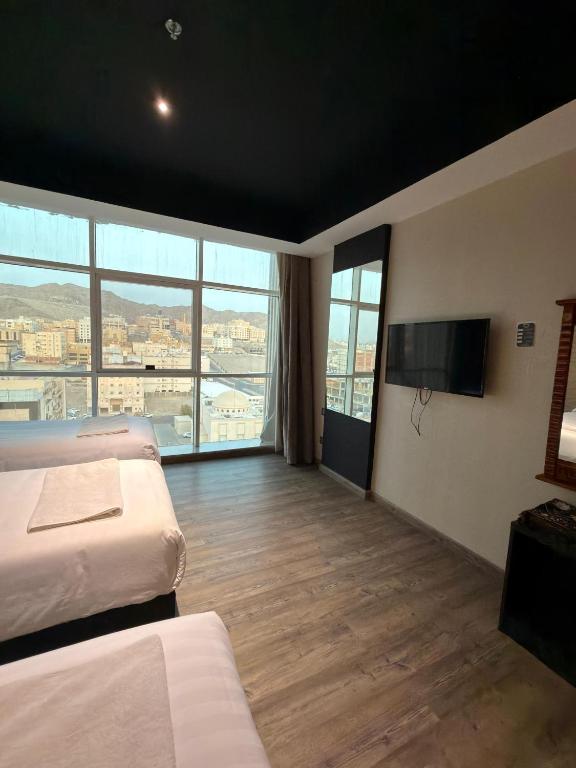 a hotel room with two beds and a flat screen tv at فندق قصر الكادي in An Nikāshah