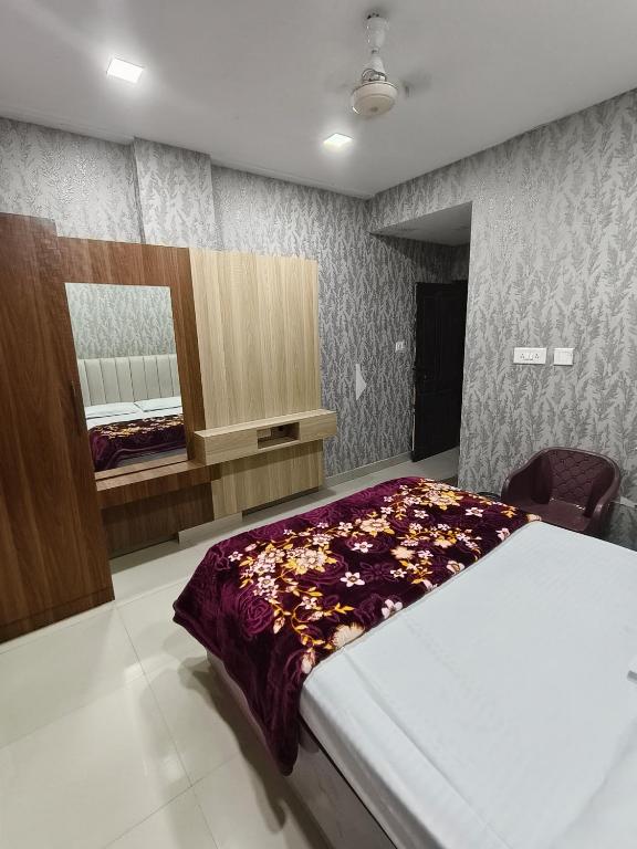 a bedroom with a bed and a mirror in it at Hotel Relax Inn in Madikeri