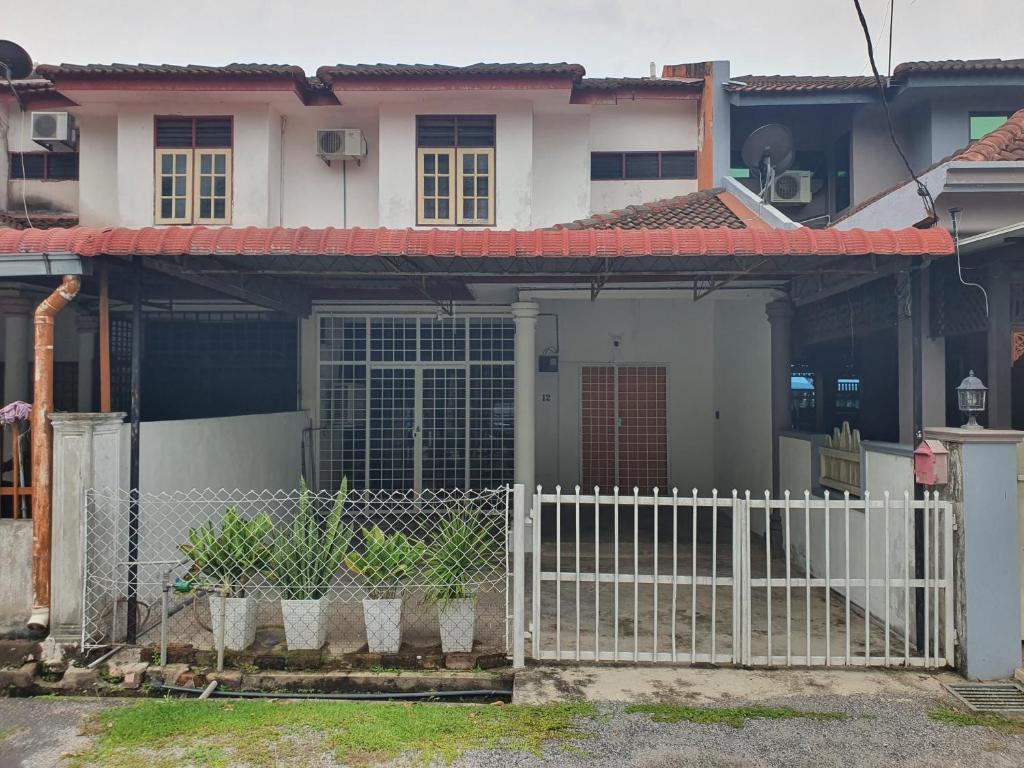 a white fence in front of a house at De'Garden 12 in Alor Setar