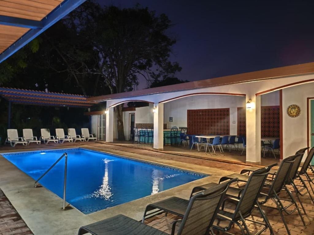 a swimming pool at night with chairs and a table at Las Catalinas Coronado in Playa Coronado