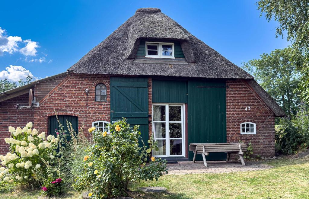 a red brick house with a thatched roof at Reetdachhaus Sünsbarg in Simonsberg