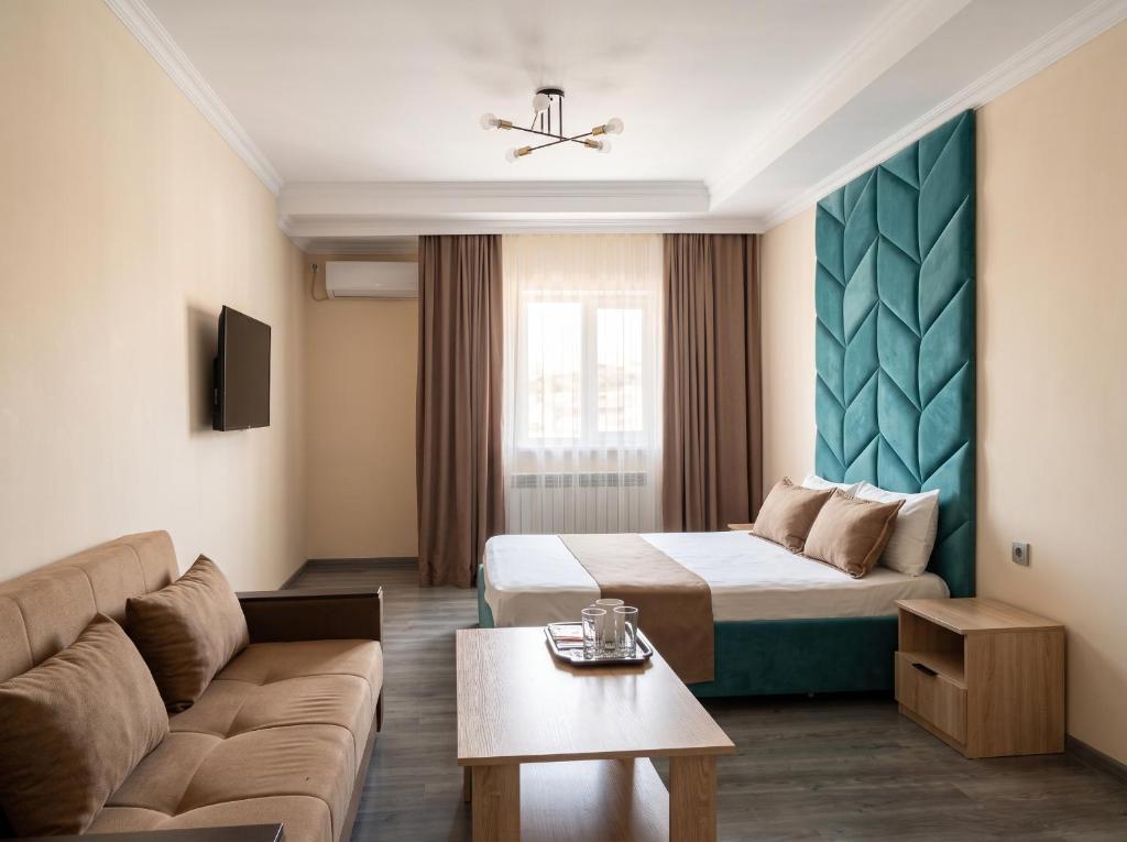 a hotel room with a bed and a couch at Avangard Hotel in Almaty