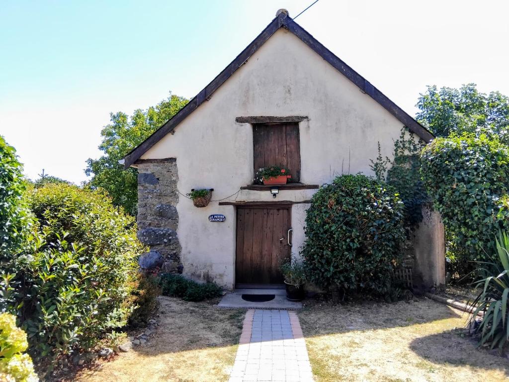 a small white building with a door and a window at La Petite Grange in Langourla