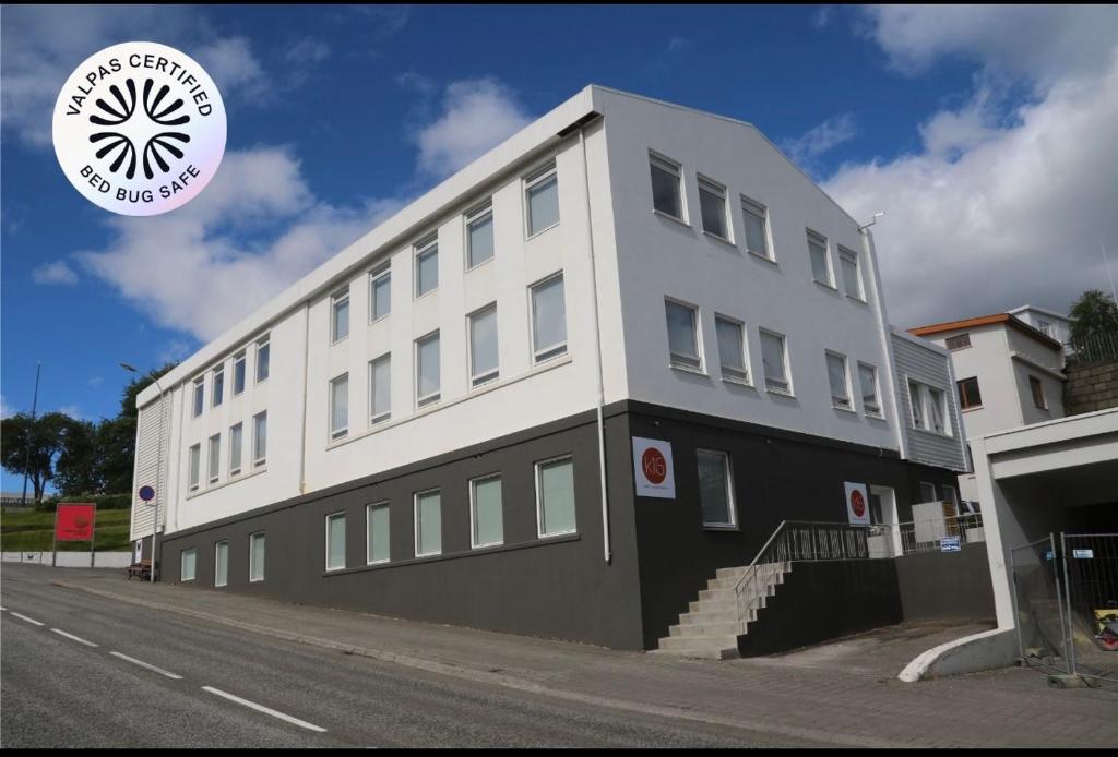 a large white building on the side of a street at K16Apartments in Akureyri
