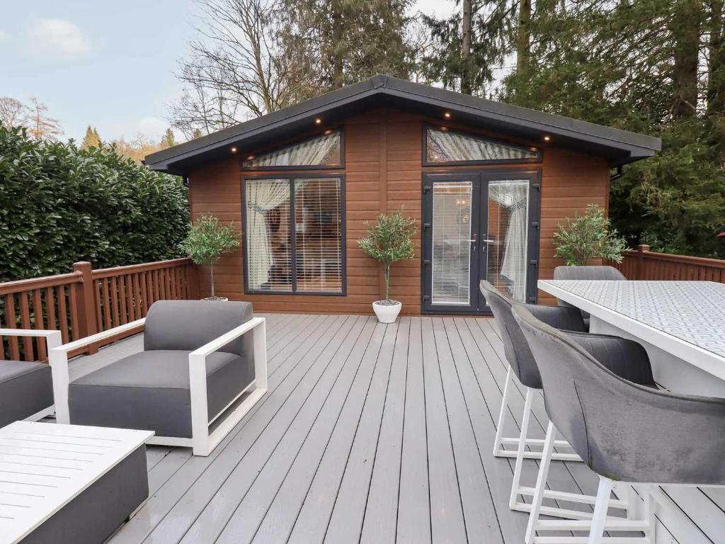 a wooden deck with chairs and a house at Luxury 2 Bedroom Lodge at White Cross Bay, Windermere in Windermere