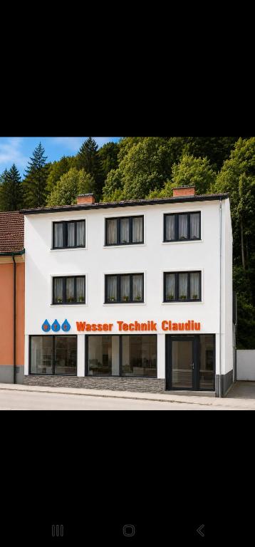 a white building with a sign on the side of it at Deea Apartment in Schottwien