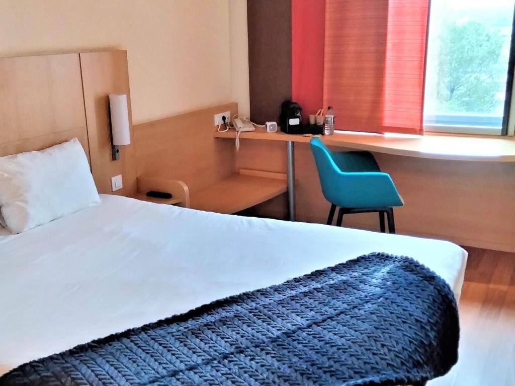 a bedroom with a bed and a desk and a chair at Ibis Barcelona Mollet in Mollet del Vallès