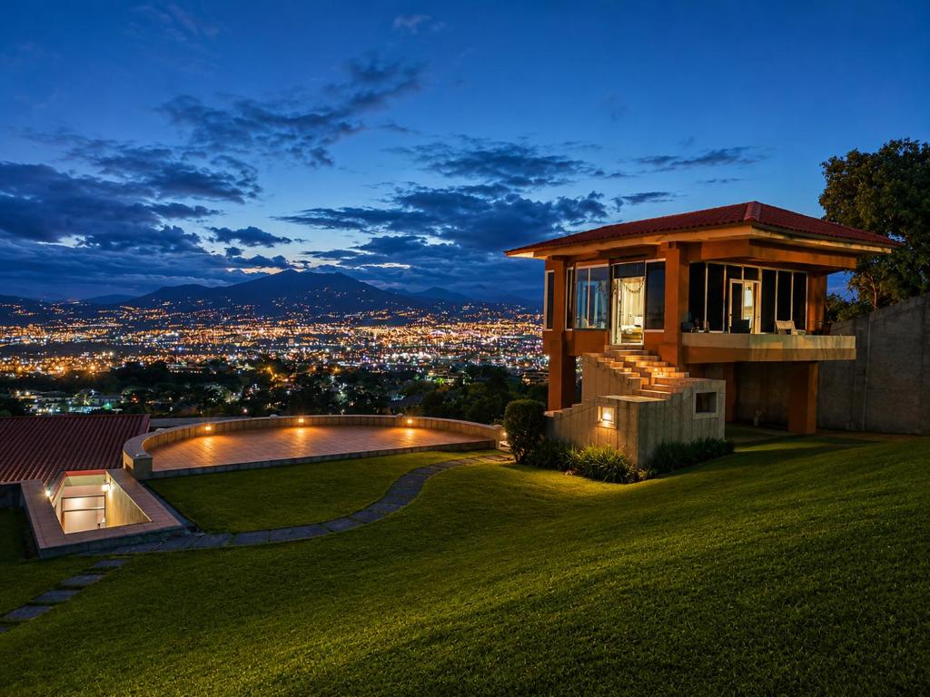 a house on a hill with a view of a city at Hotel Monte Campana Escazu in San José