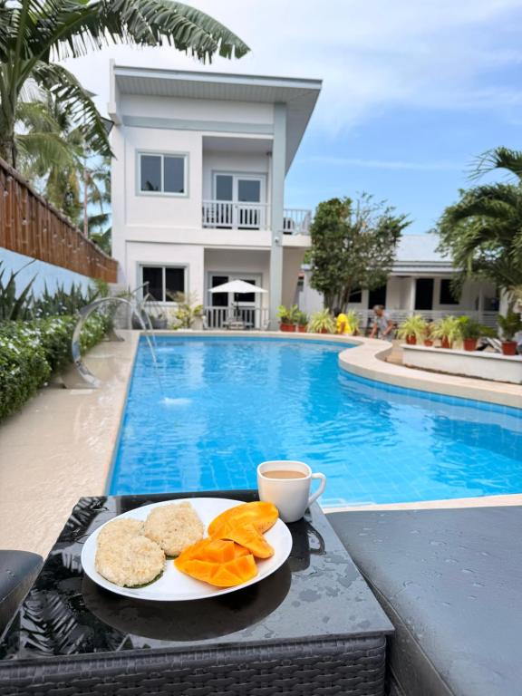a plate of food on a table next to a swimming pool at Olliz Huvila in Siquijor