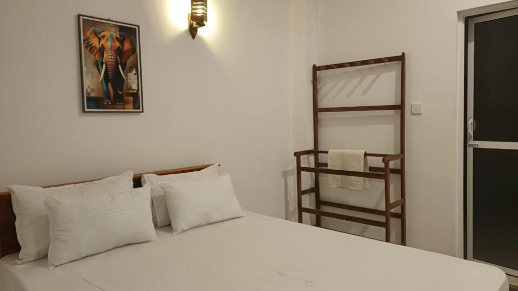 a bedroom with a white bed and a mirror at villa calm haven in Unawatuna