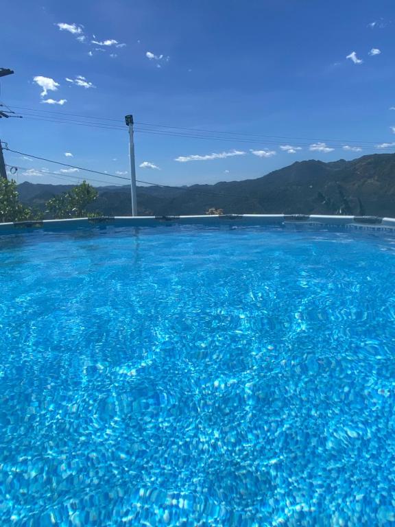 a large pool of blue water with mountains in the background at Habitaciones cama doble in La Vega